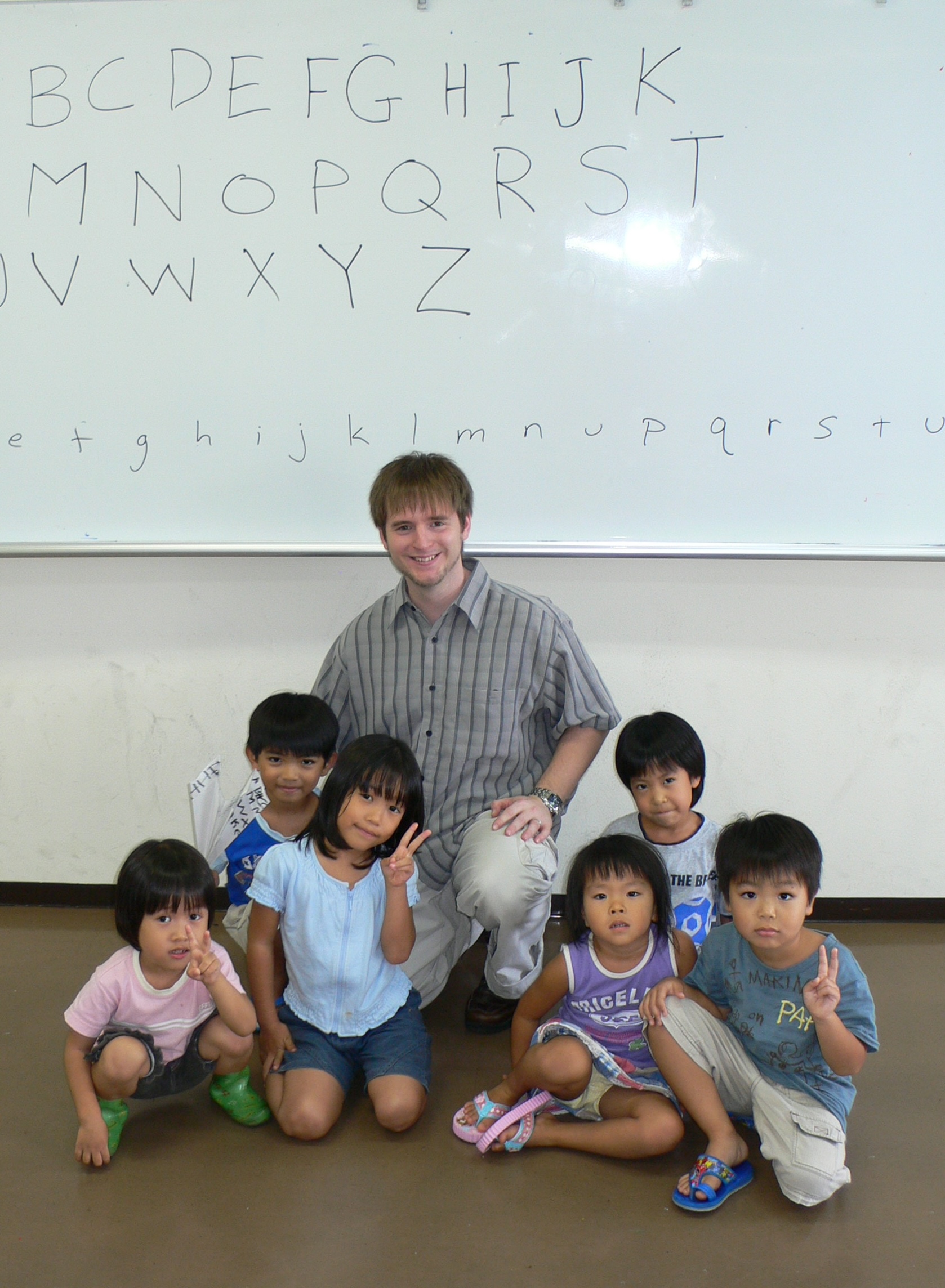 Students in front of a traditional Okinawan building